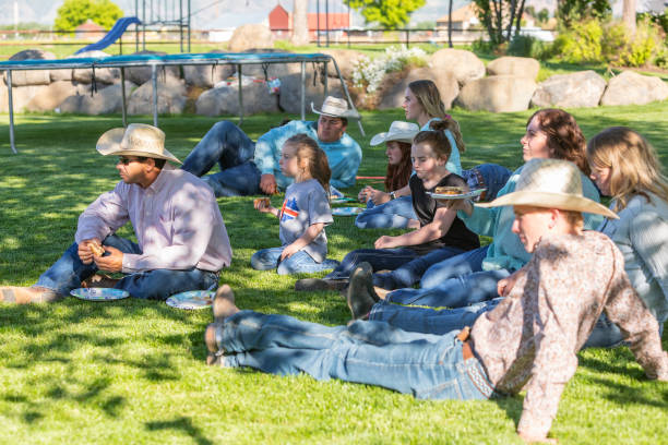 istock Family Group Sitting Eating Lunch in Dappled Light 1067716636