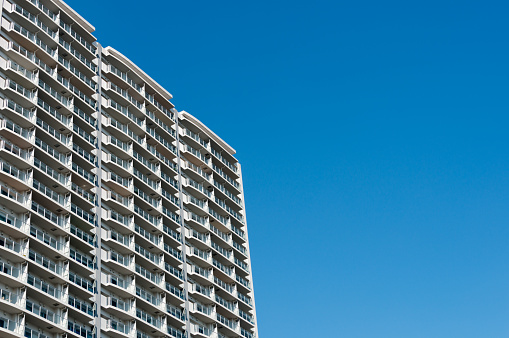 High-rise condominium in Yokohama, Japan. Low angle view of the building against blue sky.