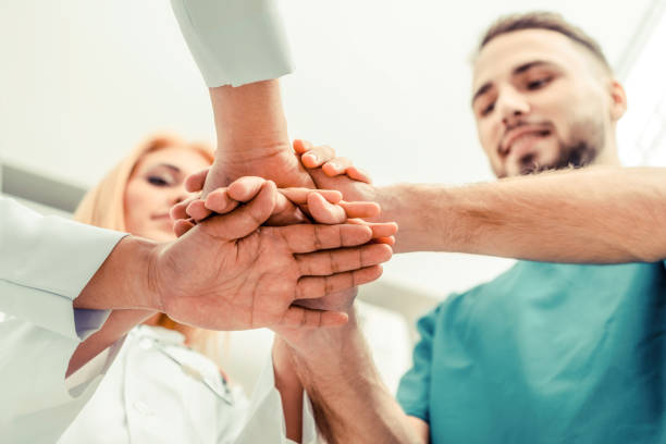 istock Doctor, surgeon and nurse join hands together. 1067721102