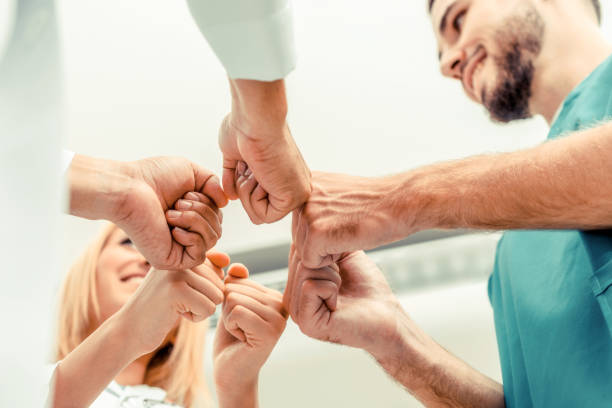 istock Doctor, surgeon and nurse join hands together. 1067721136