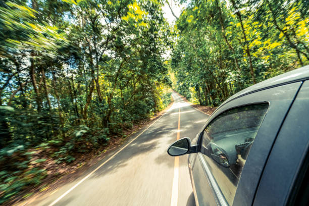 istock Side view of car driving on road in forest highway 1067722700