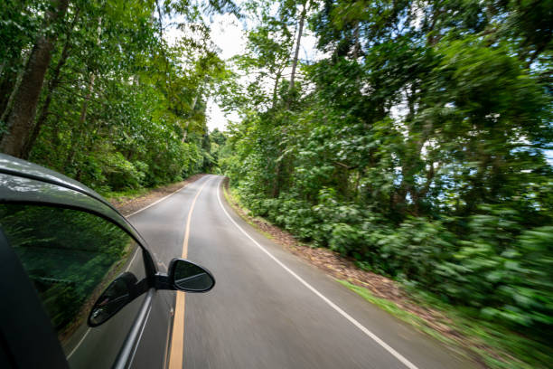 istock Side view of car driving on road in forest highway 1067722812