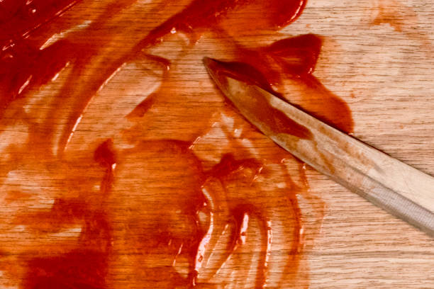 The blade of the knife is located in the blood, which is smeared on the floor, a conceptual photo