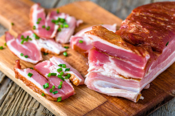 istock Smoked bacon on wooden table, pork meat 1067723526