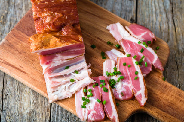 istock Smoked bacon on wooden table, pork meat 1067723590