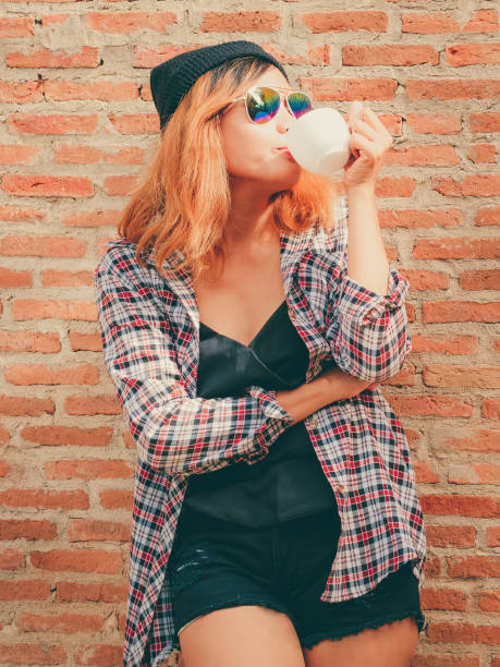 istock Happy young woman standing against brick wall. 1067724074