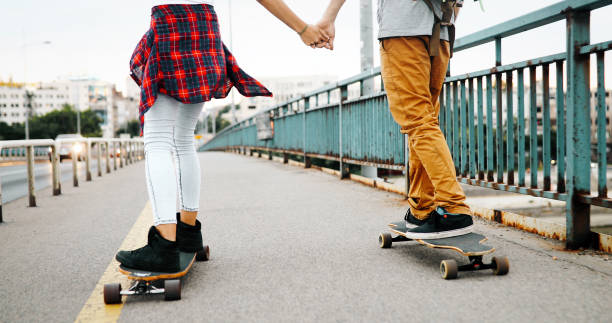 istock Young attractive couple riding skateboards and having fun 1067733980