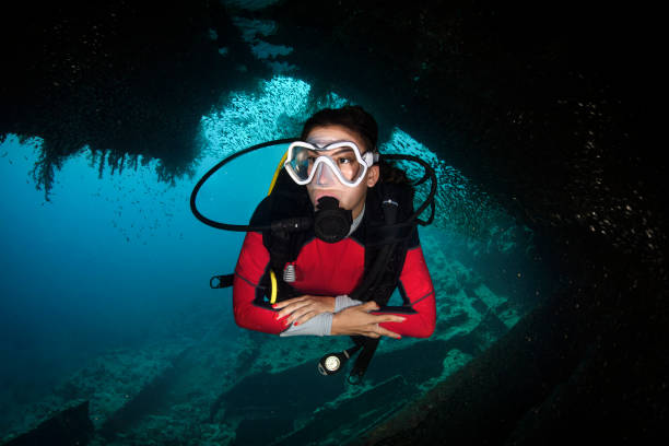 istock Female Scuba diver inside a school of silverfish 1067743498