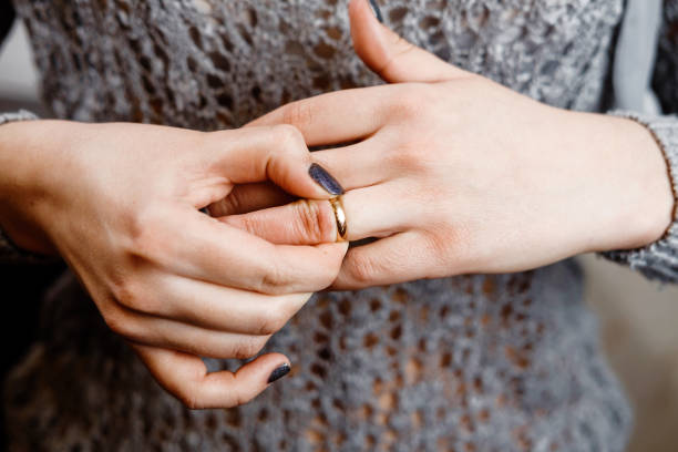 mujer saca un anillo de compromiso, conflicto familiar, primer plano - anillo fotografías e imágenes de stock