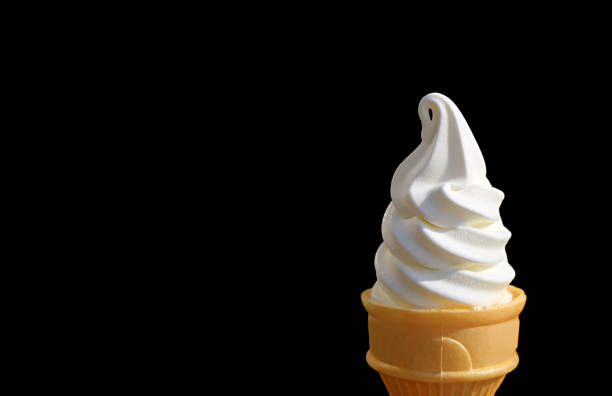istock Vanilla Soft Serve Ice Cream Cone Isolated on Black Background with Free Space for Text and Design 1067748372