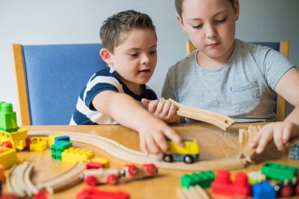 hermanos jugando con bloques, trenes y coches - tren miniatura fotografías e imágenes de stock