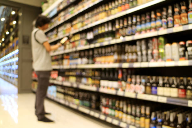 resumen foto borrosa de un hombre mirando las mercancías frente a estante de la tienda de comestibles en una tienda - vertical wine bottle variation rack fotografías e imágenes de stock