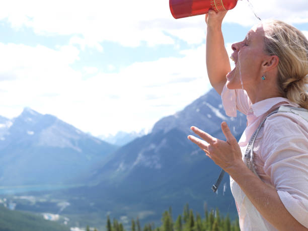 istock Hiker pours water on her head 1067753142