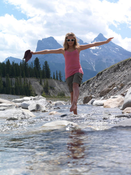 istock Young girl balances while walks up stream 1067753306