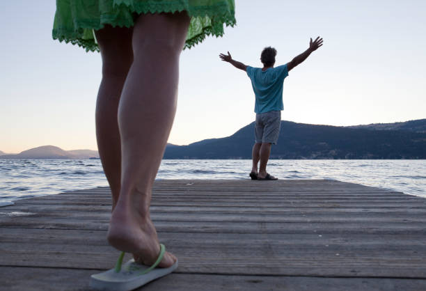 Woman approaches man on dock