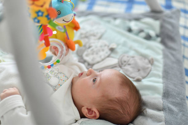 istock Baby boy playing with hanging toys on developing mat 1067754066