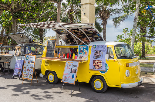 Bali, Indonesia - October 20, 2018: Food truck in a classic yellow volkswagen van at the Garuda Wisnu Kencana Cultural Park