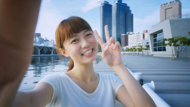 スマート フォン selfie を使用してアジアの女の子 - 自分撮り ストックフォトと画像