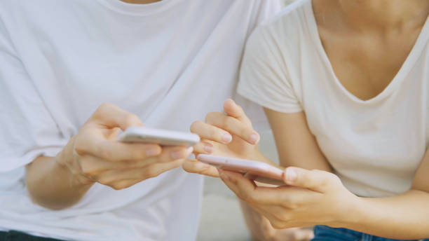 istock Asian couple using smart phone in park 1067758624