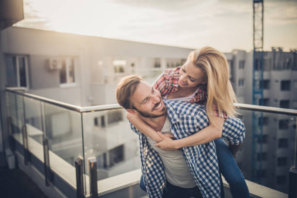 istock Young happy couple having fun while piggybacking on a penthouse terrace. 1067759556