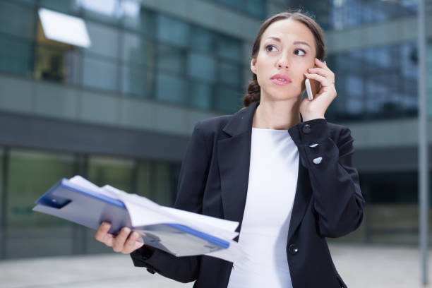 istock Woman boss with folder is talking phone about the project 1067762502