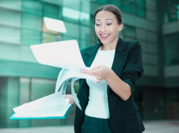 mujer está examinando documentos - success signing businesswoman serious fotografías e imágenes de stock