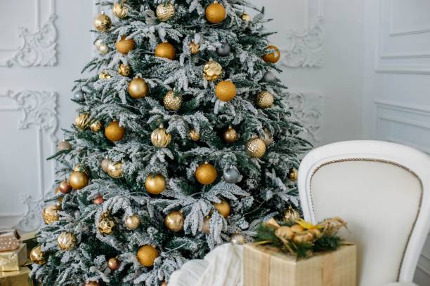 istock Christmas gifts under the tree. Yellow decorative balls. 1067762918