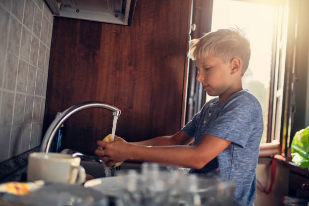 istock Little boy cleaning dishes 1067764704