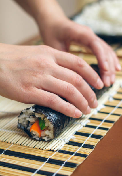 istock Woman chef hands rolling up japanese sushi 1067764928