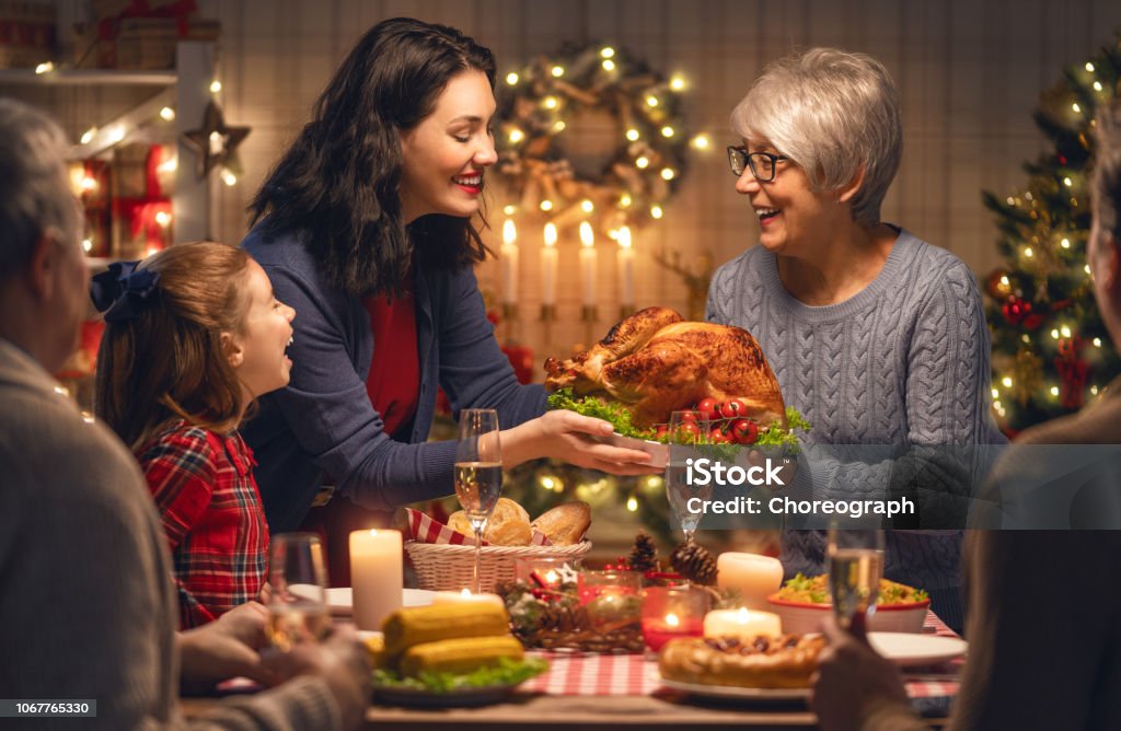 family celebrating Christmas Merry Christmas! Happy family are having dinner at home. Celebration holiday and togetherness near tree. Christmas Stock Photo