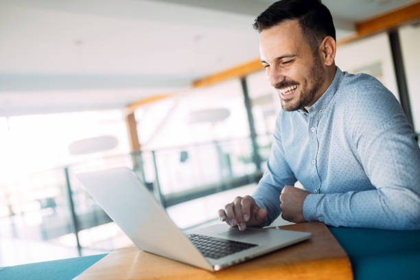 istock Smiling male blogger keyboarding article in electronic newspaper using laptop 1067765852
