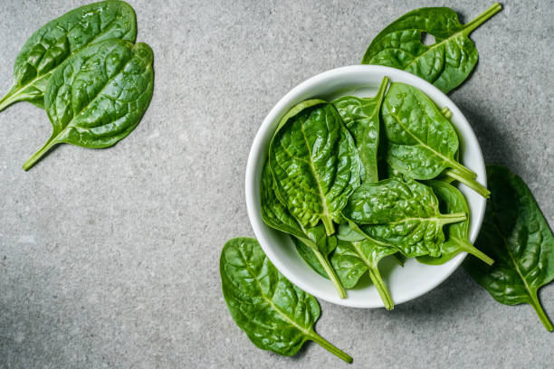 istock Top view of wet spinach leaves in bowl 1067767994