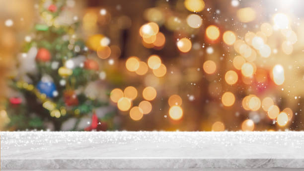 istock Empty white marble stone table top with bokeh light on blurred Christmas tree banner background with snowfall - can be used for display or montage your products. 1067768718