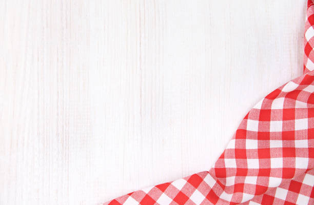 Red picnic cloth on white wooden background.