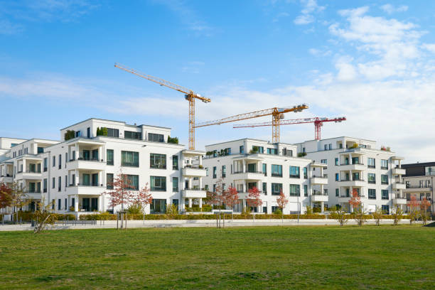 fileira de casas brancas de apartamento e canteiro de obras - clear sky built structure apartment sky - fotografias e filmes do acervo