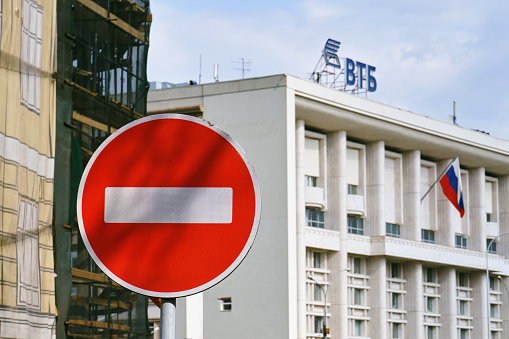 Moscow, Russia - April 30, 2018. No Entry road sign with the VTB russian bank building and flag of Russia on the background