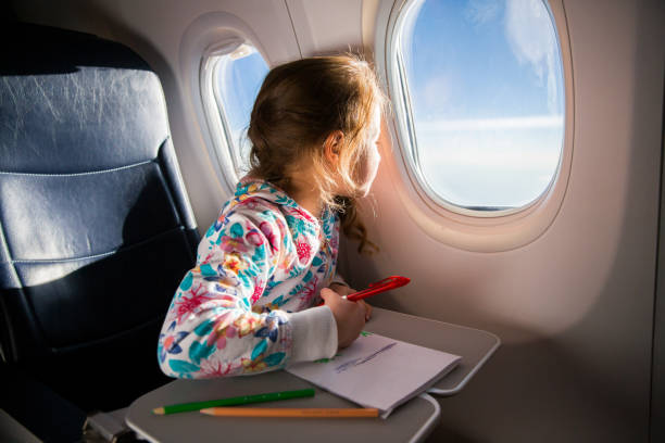 Child drawing picture with crayons in airplane. stock photo