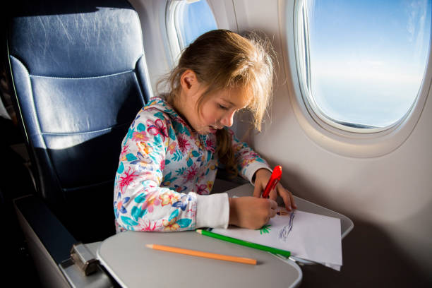 istock Child drawing picture with crayons in airplane. 1067772760