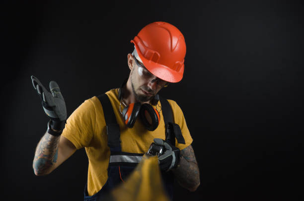 istock a young man posing on a black background in a work uniform and a construction tool 1067772924