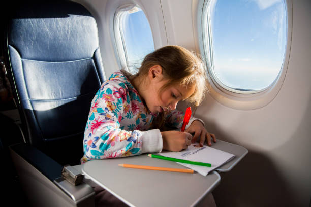 istock Child drawing picture with crayons in airplane. 1067773268