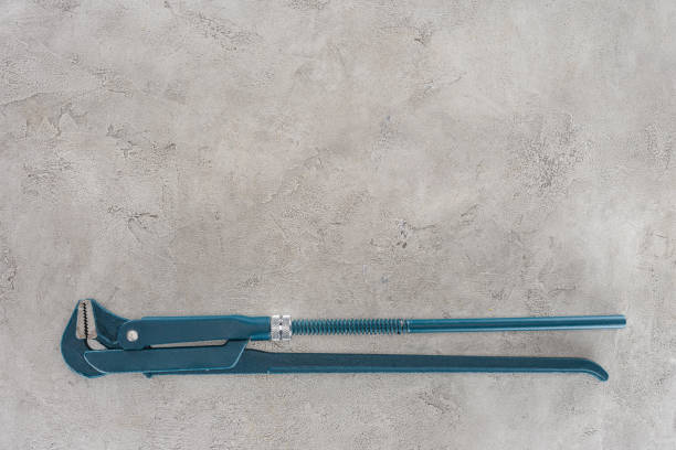 top view of plumber wrench lying on concrete surface