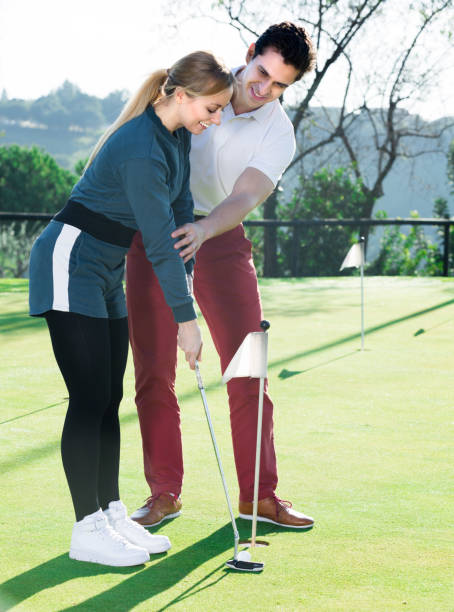 istock Young man is training female to play golf 1067780822