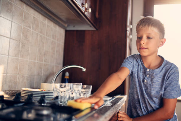 istock Little boy cleaning up kitchen 1067782386