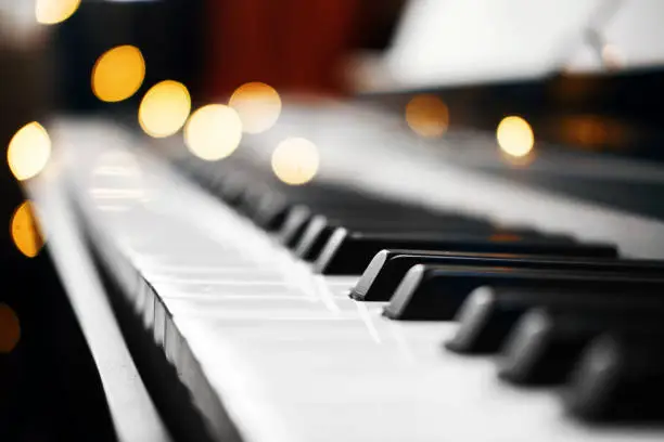 Photo of piano keys bokeh in the background Christmas lights