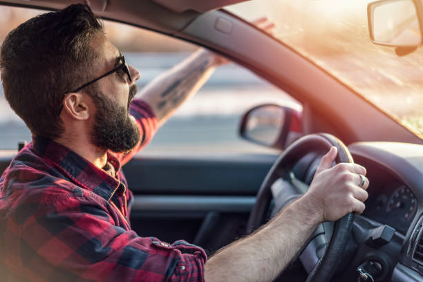 homem jovem como ele dirige a gritar pela janela do carro - furious road rage driver road - fotografias e filmes do acervo