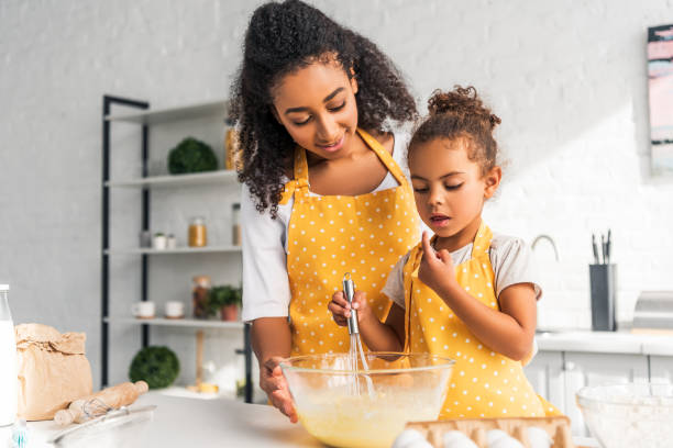 istock african american daughter preparing and whisking dough in kitchen 1067784370
