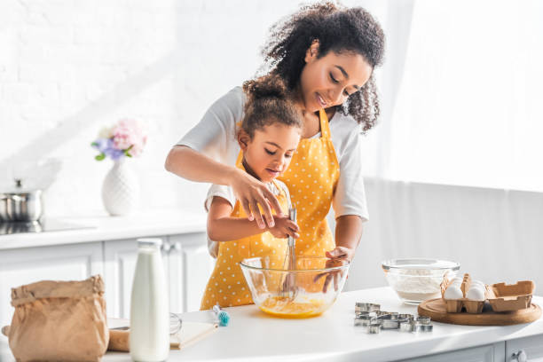 istock african american mother helping daughter whisking eggs for dough in kitchen 1067784634