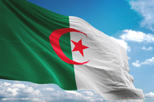 istock Algeria flag waving isolated cloudy sky background 1067784964
