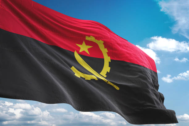 istock Angola flag waving isolated cloudy sky background 1067785024