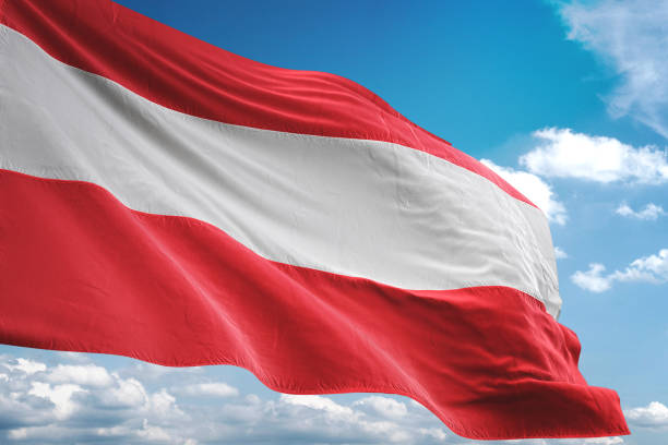 istock Austria flag waving isolated cloudy sky background 1067785136